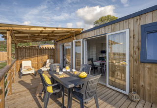 Outdoor terrace with dining table and sun loungers at Camping Saint Pabu Plage - Glamping Bretagne, France.