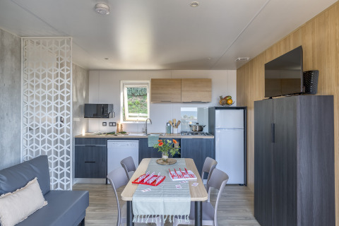 Sistemazione glamping moderna al Camping Saint Pabu Plage in Bretagna con cucina e zona pranzo.