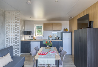 Moderne glamping accommodatie bij Camping Saint Pabu Plage in Bretagne met keuken en eethoek.