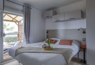 Chambre de glamping moderne au Camping Saint Pabu Plage en Bretagne avec lit confortable et terrasse.