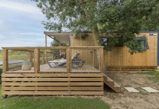 Hébergement glamping au Camping Saint Pabu Plage avec terrasse en bois et transats en Bretagne, France.