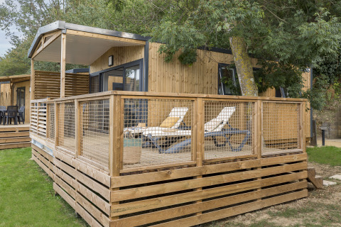Hébergement glamping moderne au Camping Saint Pabu Plage en Bretagne, terrasse en bois et transats.