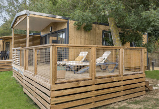Hébergement glamping moderne au Camping Saint Pabu Plage en Bretagne, terrasse en bois et transats.