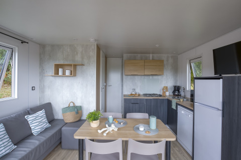 Hébergement glamping moderne au Camping Saint Pabu Plage en Bretagne avec cuisine et coin salon.