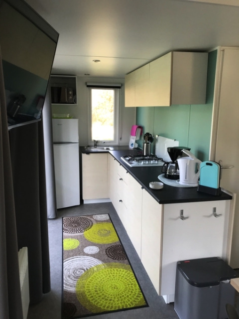 Moderne glampingkøkken i Camping Ammertal - Stacaravans Beieren med faciliteter og farverig måtte.
