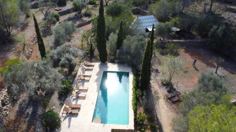 Aerial view of Refugio Marnes glamping site featuring a pool, lounge chairs, and natural Spanish scenery.