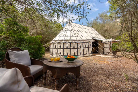 Glamping-Unterkunft bei Refugio Marnes in Spanien mit Zelt, Sitzbereich und Blick auf die Natur.