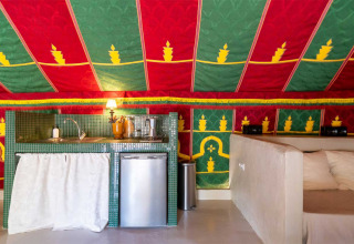 Glamping kitchen with mini fridge, sink and colorful tent ceiling at Refugio Marnes - Agriturismo Spanje.
