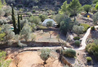 Luchtfoto van glamping Refugio Marnes, omringd door terrassen, bomen en natuur in Spanje.
