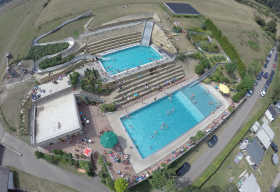 Luftfoto af Camping Altschmiede - Lodges Rijnland-Palts med swimmingpools, vandrutschebane og campingareal.