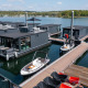 Flotte moderne husbåde ved Houseboat Marina Mookerplas i Holland, med både og rolige omgivelser.