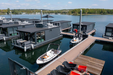 Moderne Hausboote in der Houseboat Marina Mookerplas, Niederlande, mit Stegen und ruhigem Wasser.