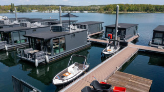 Modernas casas flotantes en Houseboat Marina Mookerplas, Países Bajos, con barcos y vista al lago.