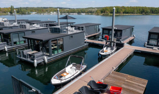 Modernas casas flotantes en Houseboat Marina Mookerplas, Países Bajos, con barcos y vista al lago.