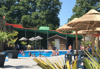 Udendørs pool og vandrutsjebane ved Vakantiepark De Oude Molen Safaritent Gelderland med folk der bader.