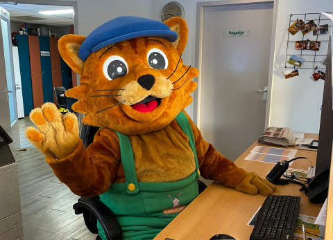 Mascotte di gatto seduta a una scrivania al Vakantiepark De Oude Molen - Safaritent Gelderland in Olanda.