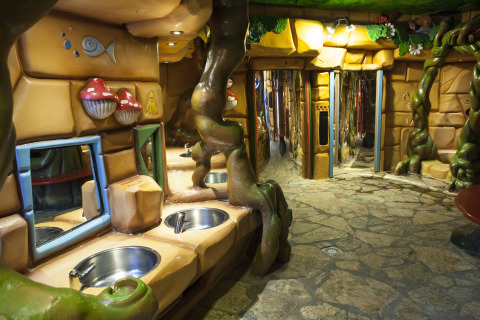 Baño temático de bosque con ramas, setas de colores y lavabos en Vakantiepark De Oude Molen, Gelderland.