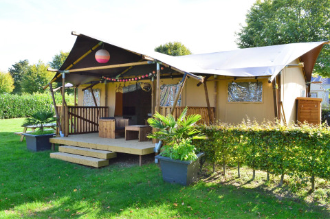 Tienda safari de glamping en Vakantiepark De Oude Molen, Gelderland, rodeada de vegetación y naturaleza.