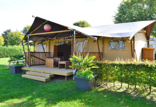 Tente safari glamping au Vakantiepark De Oude Molen en Gueldre, entourée de verdure et d’arbres.