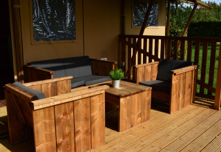 Houten loungeset met zwarte kussens op terras bij Vakantiepark De Oude Molen - Safaritent Gelderland.