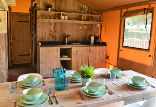 Cucina e zona pranzo accoglienti in tenda glamping a Vakantiepark De Oude Molen - Safaritent Gelderland.