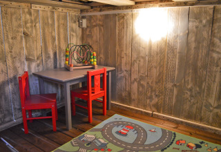 Kinderbereich im Safarizelt bei Vakantiepark De Oude Molen - Safaritent Gelderland mit Tisch und Spielteppich.