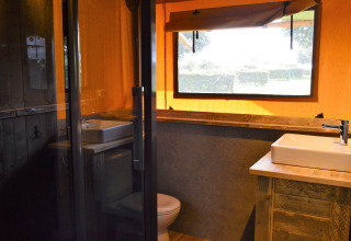 Vue intérieure de la salle de bain dans la tente glamping Vakantiepark De Oude Molen - Safaritent Gelderland.