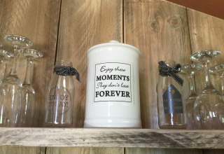 Mensola con bicchieri e barattoli decorativi presso Glamping - aan de Vleterbeke, citazione sui momenti.