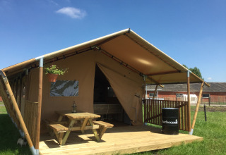 Glamping indkvartering ved navn 'Glamping - aan de Vleterbeke' med træterrasse, picnicbord og grill under telt.