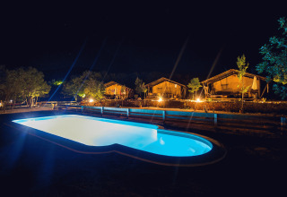 Piscina illuminata di notte davanti a lussuose tende safari al Camping Nono Ban - Safaritenten Brac.