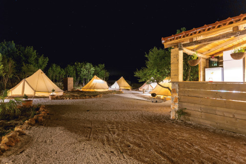 Glampingplads ved Camping Nono Ban - Safaritenten Brac, oplyste telte under nattehimlen i naturen.
