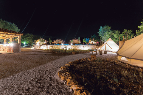Glampingovernatning på Camping Nono Ban - Safaritenten Brac med oplyste telte og hyggelig atmosfære om natten.