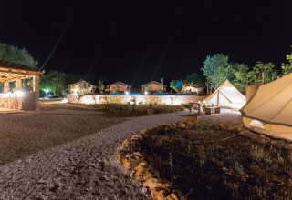 Alloggio glamping presso Camping Nono Ban - Safaritenten Brac con tende illuminate e atmosfera notturna rilassante.