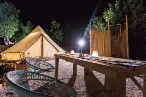 Glamping bij Camping Nono Ban - Safaritenten Brac met sfeervolle tent en zitgedeelte in de avond.