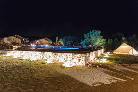 Hébergement glamping Camping Nono Ban - Safaritenten Brac avec tentes et terrasse éclairées la nuit.