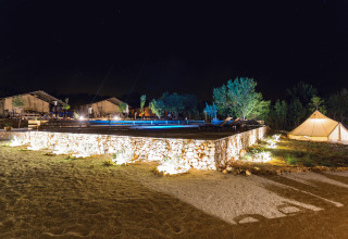 Alojamiento glamping Camping Nono Ban - Safaritenten Brac con terraza y tiendas iluminadas de noche.