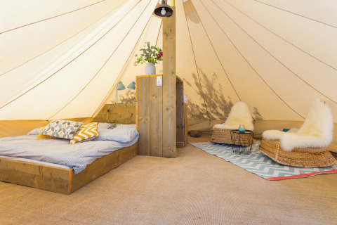 Glamping tent at Camping Nono Ban - Safaritenten Brac with cozy bed, seating area, and stylish decor.
