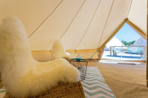 Interno di tenda glamping con sedia morbida al Camping Nono Ban - Safaritenten Brac in una giornata di sole.