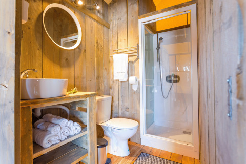 Modern bathroom in glamping at Camping Nono Ban - Safaritenten Brac with wooden walls and shower cabin.