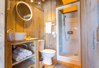 Salle de bain moderne dans un glamping Camping Nono Ban - Safaritenten Brac avec murs en bois et douche.
