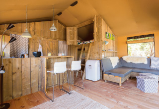 Interieur van een gezellige glampingtent bij Camping Nono Ban - Safaritenten Brac met houten accenten.