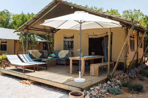 Hébergement glamping Camping Nono Ban - Safaritenten Brac avec terrasse, chaises longues et parasol.
