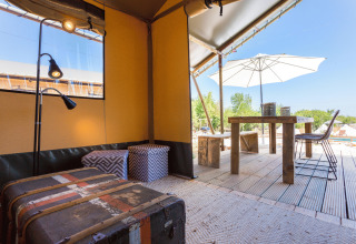 Interno di un glamping elegante con arredi in legno e terrazza esterna presso Camping Nono Ban - Safaritenten Brac.