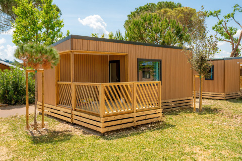 Moderner Cottage auf dem Trasimeno Glamping Resort inmitten grüner Natur, ideal für erholsame Ferien.