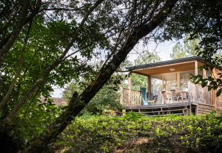Alojamiento glamping en Huttopia Les Chateaux, Val de Loire, rodeado de árboles y terraza acogedora.
