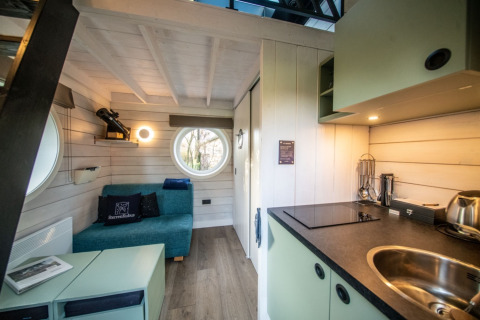 Interiør af glampingbolig Erfgoed Bossem - Sterrenkubussen Twente, moderne design med sofa og tekøkken.
