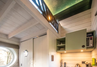 Binnenzicht van glamping accommodatie met sterrenhemelplafond bij Erfgoed Bossem - Sterrenkubussen Twente.