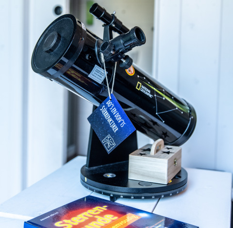 National Geographic-telescoop op tafel met houten doosje en sterrenboek, ideaal voor Twente.
