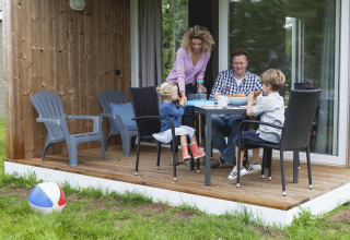 Gezin ontbijt op het terras van een glamping-lodge bij Strand49 in Noord-Holland.