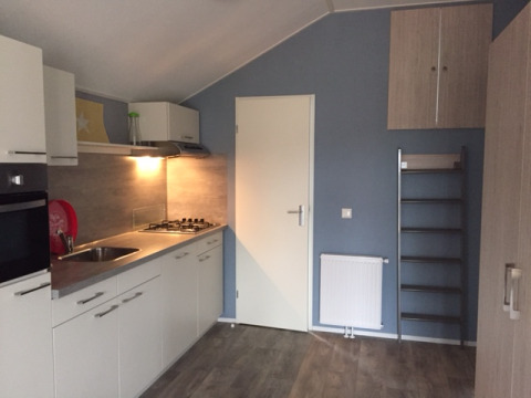 Coin cuisine moderne de Strand49 - Strandlodges & Cabins Noord-Holland avec évier, plaques et placards.